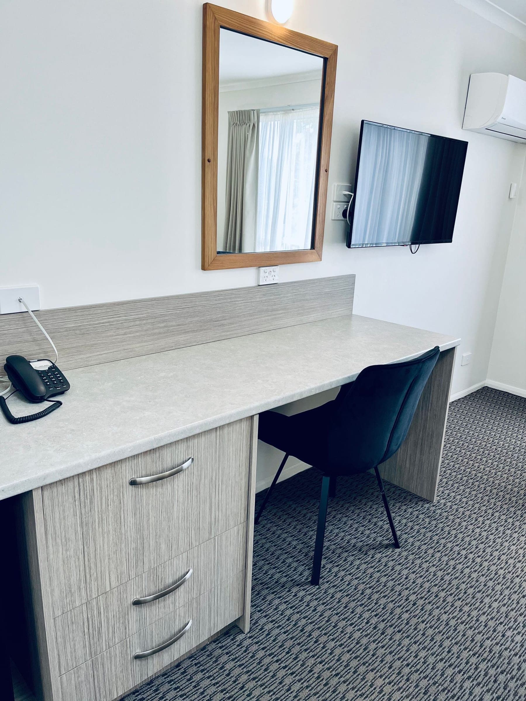 Apartment interior with desk and kitchenette at the Heemskirk Motor Hotel
