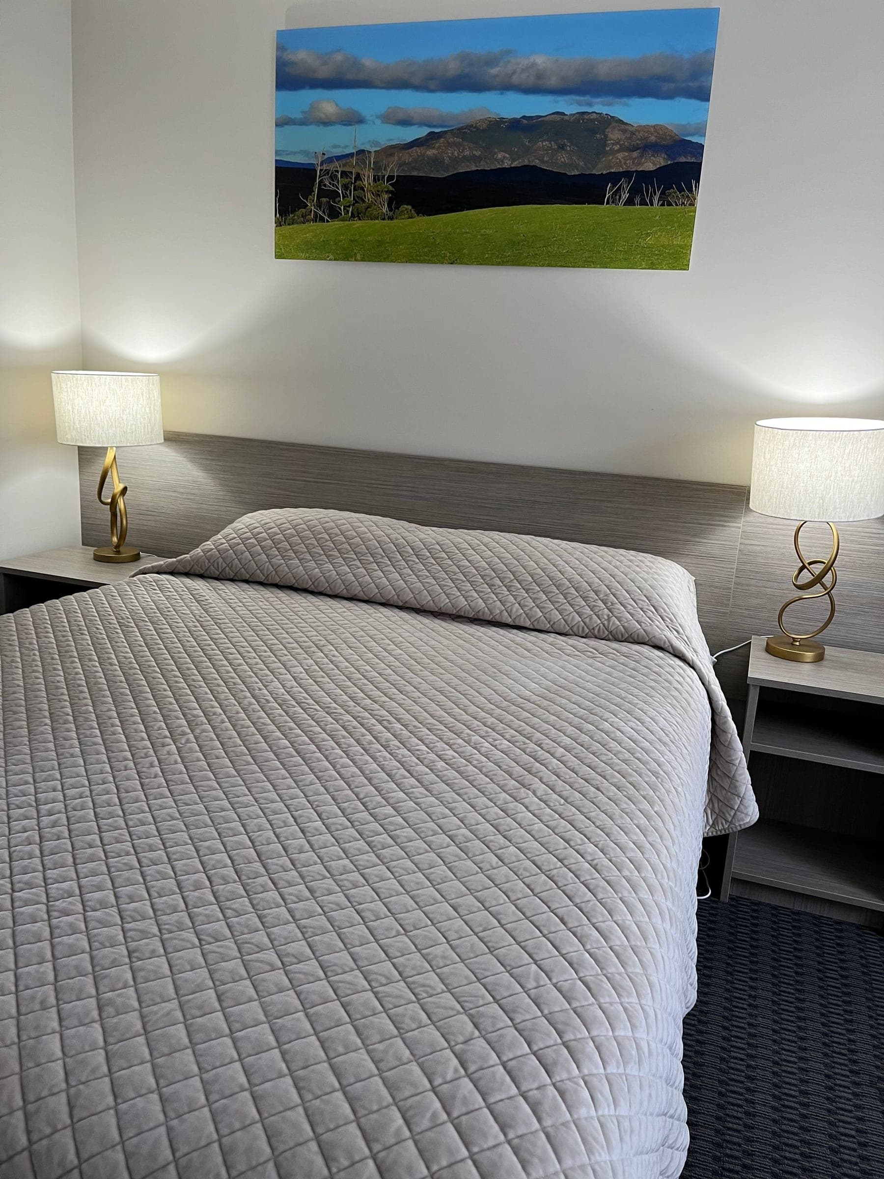 Double guest room with timber headboard and bedside lamps at the Heemskirk Motor Hotel